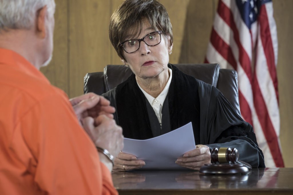 Judge at desk talking to inmate