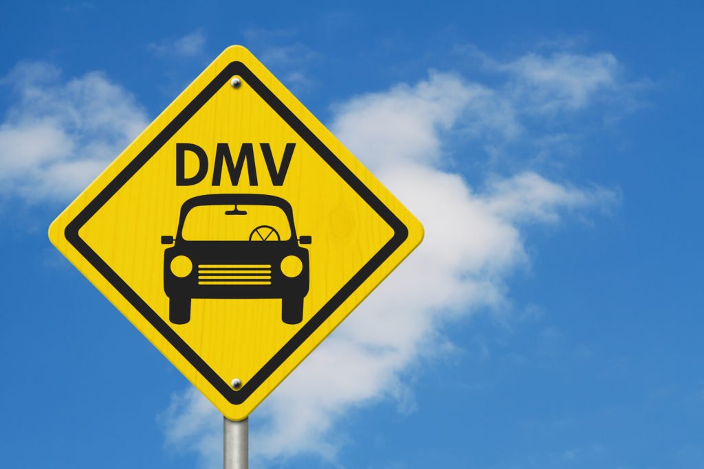 DMV sign against blue sky with clouds