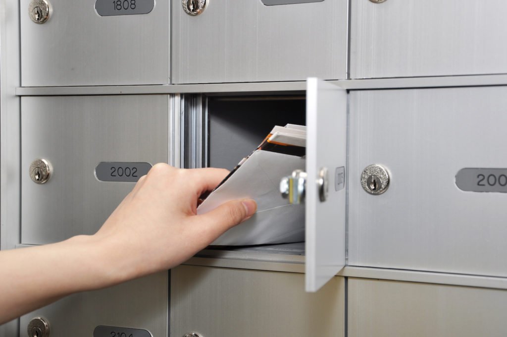 Mano alcanzando el buzón para recibir correo - Las cartas de demanda civil se envían generalmente por correo de los Estados Unidos