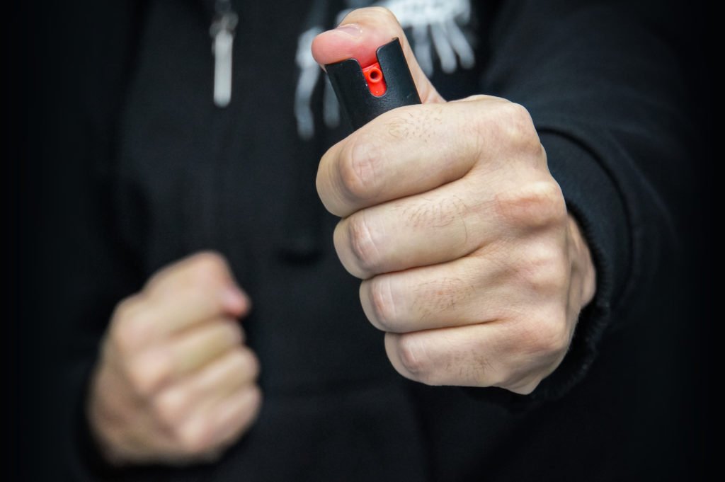 Close-up of police hand holding up pepper spray