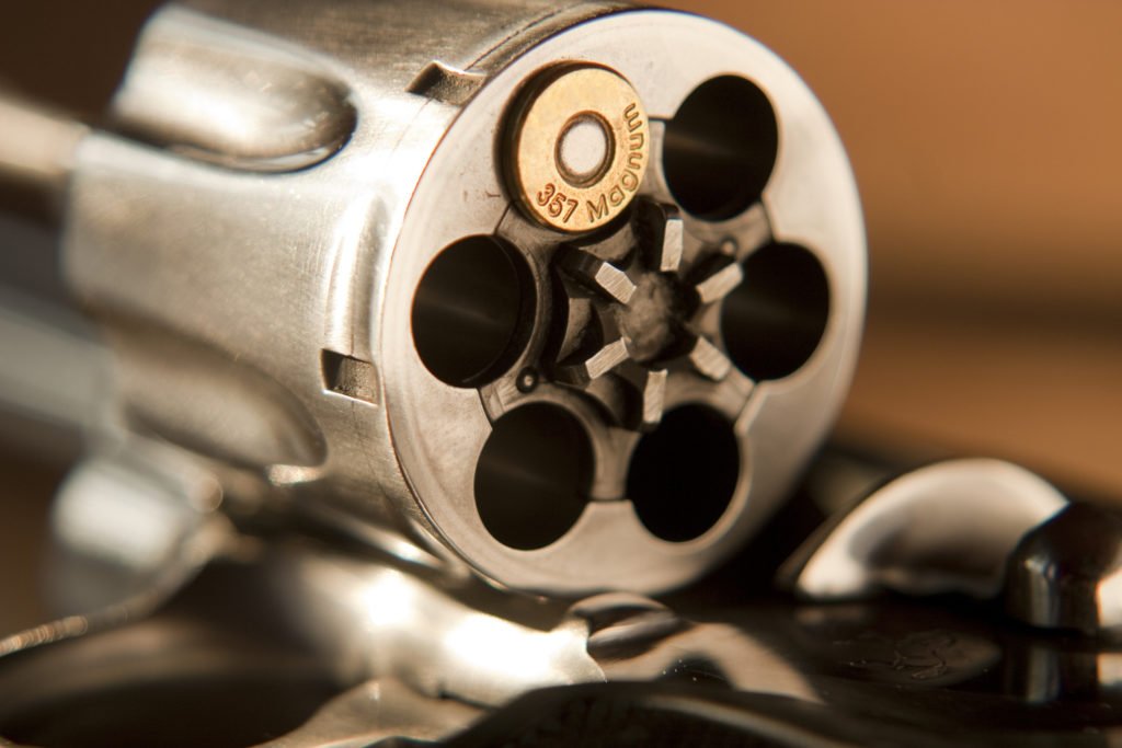 Barrel of gun showing one bullet in cartridge