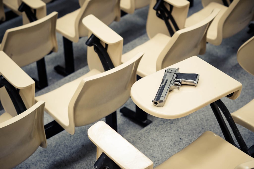 Arma en un escritorio en una escuela como ejemplo de una violación del CRS 18-12-105.5