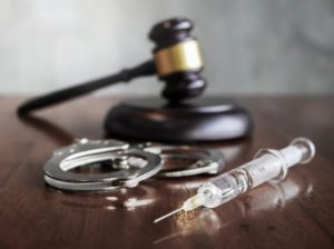 Gavel, cuffs, and lethal injection syringe