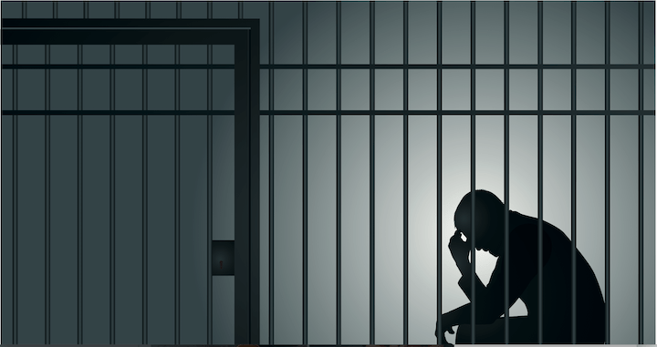 Silhouette of man sitting behind bars