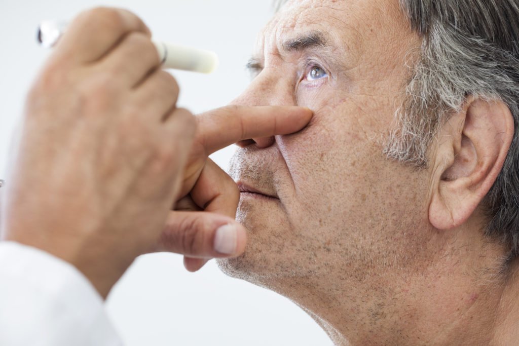 Doctor shining light into patient's eye