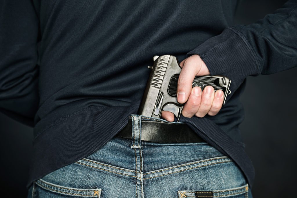 Man with revolver in back waistband as an example of possession of a weapon by a previous offender in Colorado