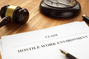 Wooden judge's gavel on a desk along with a paper that says "claim for hostile work environment"