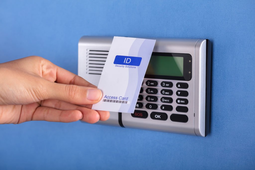 Closeup of hand using ID card to gain access