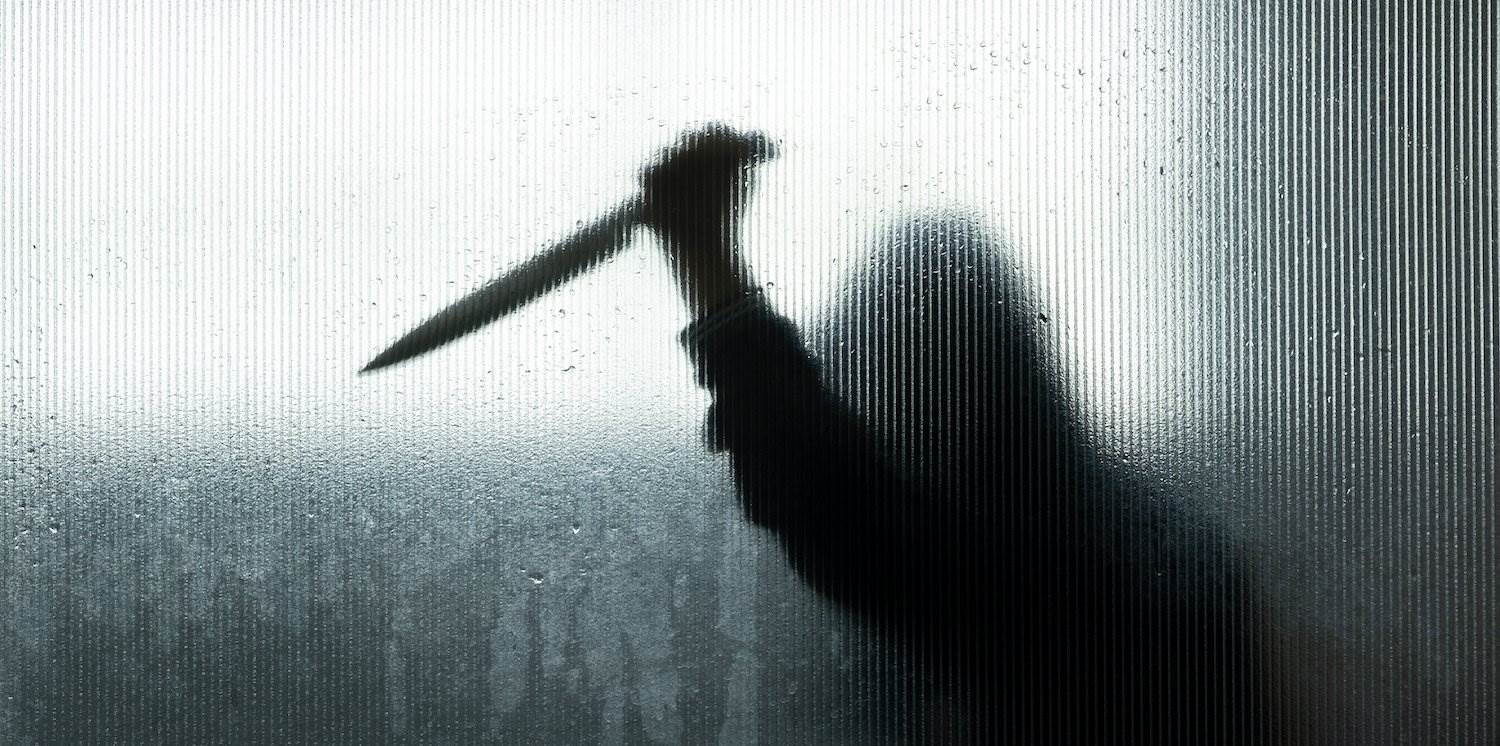 Silhouette of man about to stab someone