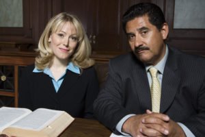 Two attorneys smiling at desk