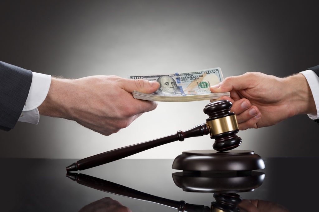 Judge with gavel handing cash to plaintiff