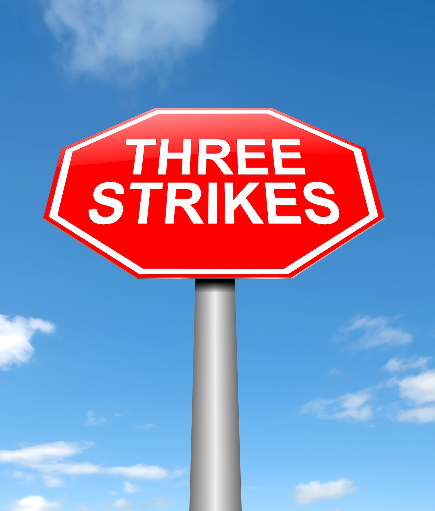 Sign that says "Three Strikes" against blue sky