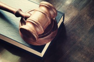 Gavel and law book on wood table