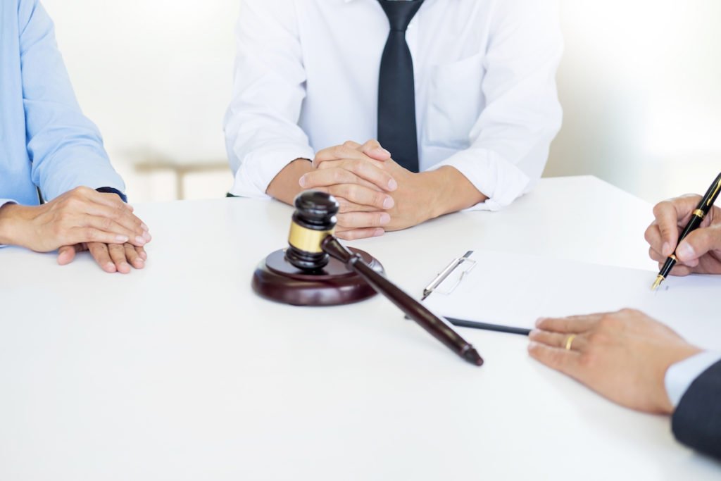 DMV hearing with judge, defendant and attorney at a table with a gavel in the middle