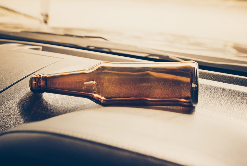 Botella de cerveza vacía cerca del tablero después de un accidente fatal por DUI