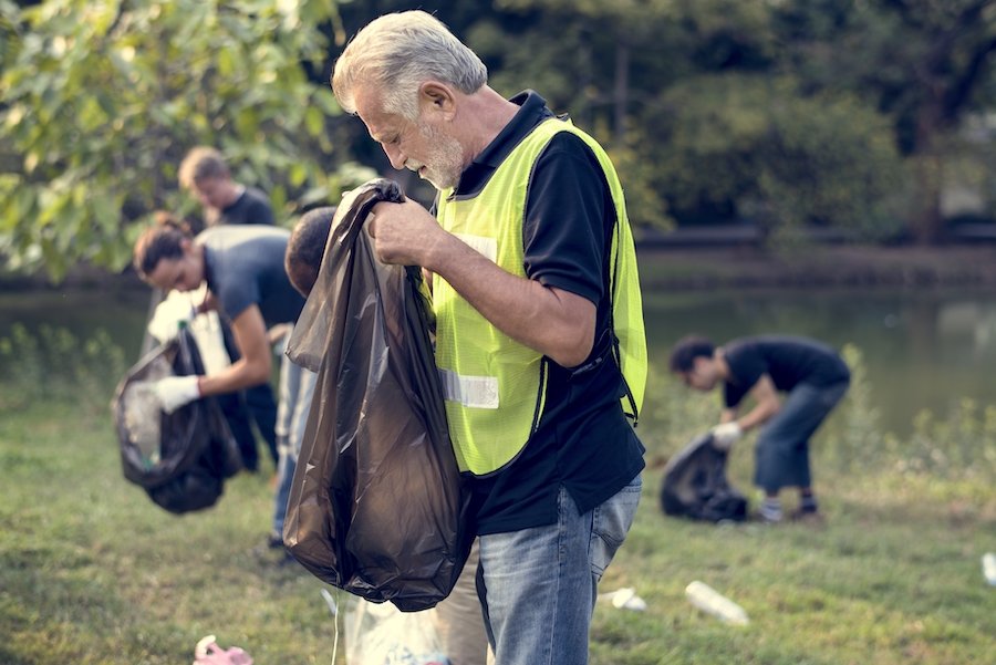 Man gathering trash from field