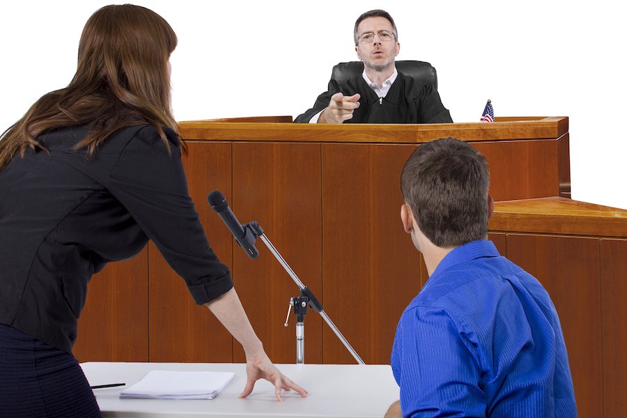 Juez hablando con el acusado y el abogado en el tribunal