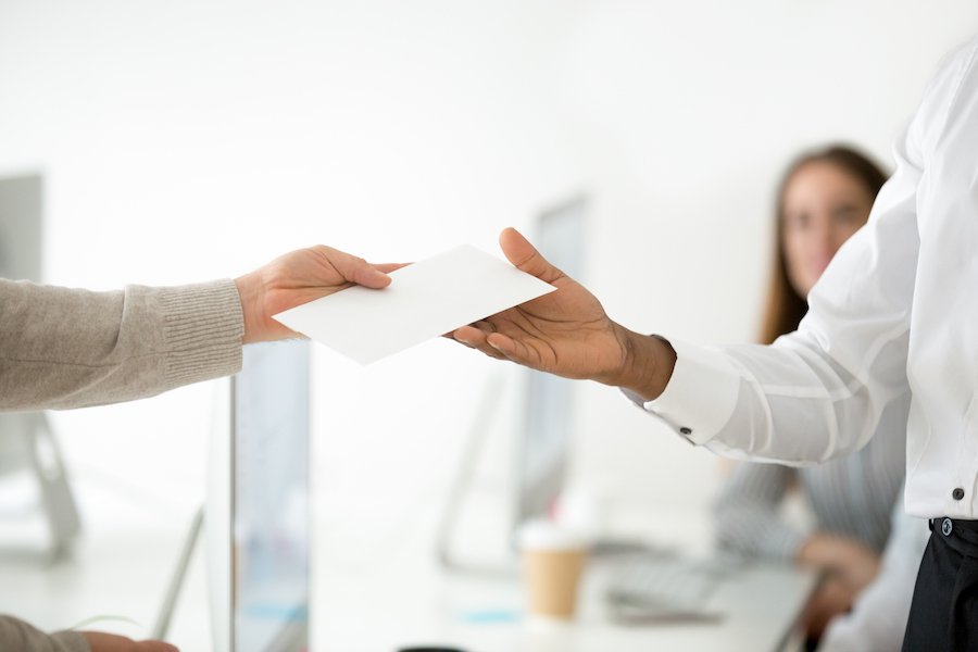 Boss handing paycheck to employee