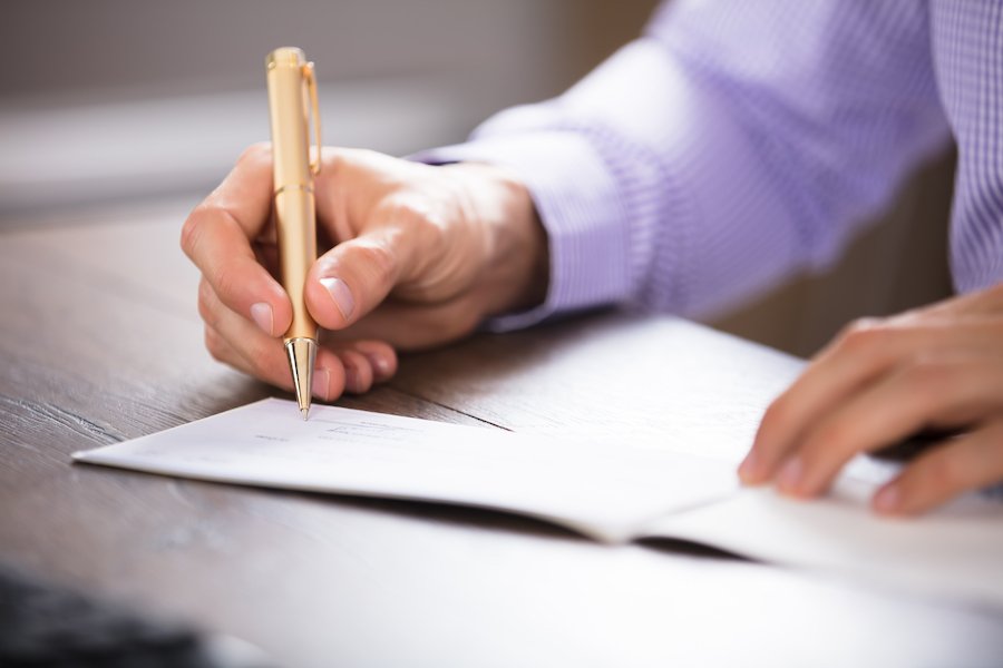 Closeup of hand writing a check