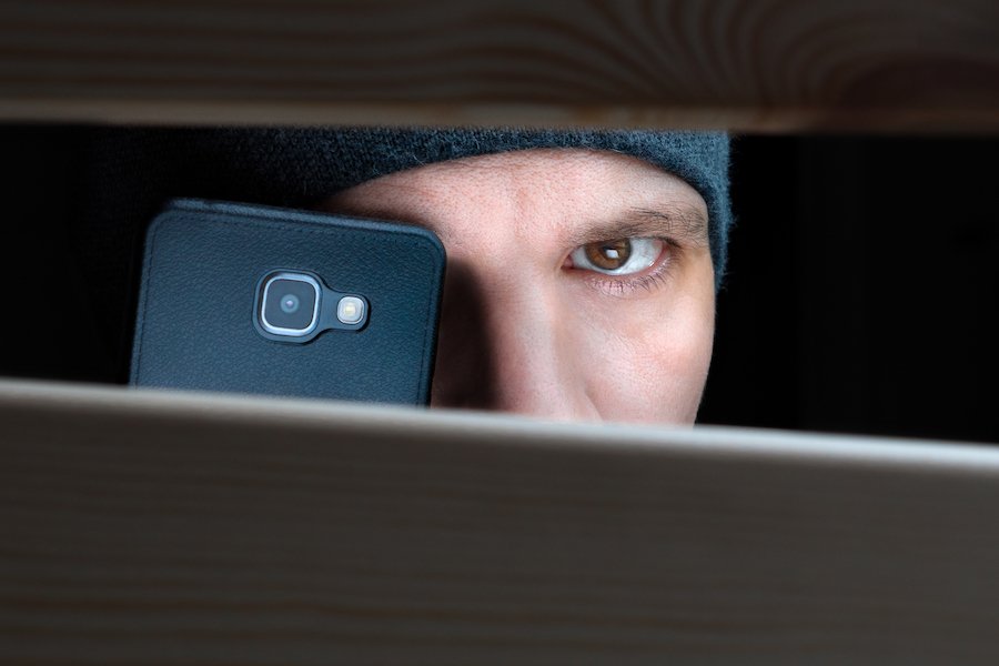 Hombre con iPhone presumiblemente tomando fotos de una mujer desnuda sin su conocimiento en violación de CRS 18-7-801.