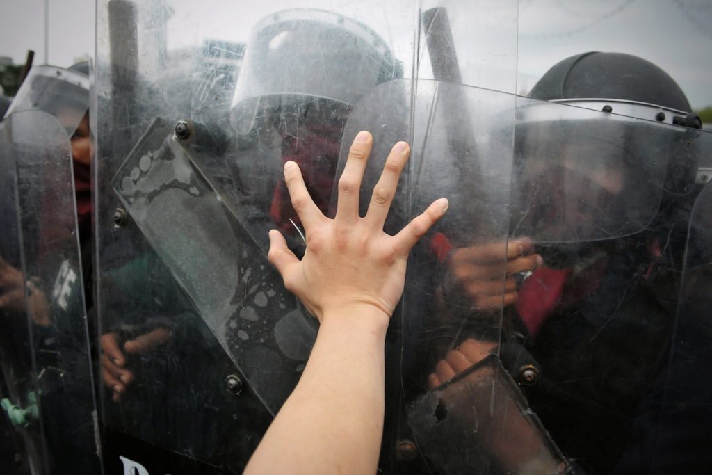 Persona presionando contra una barricada policial como ejemplo de batería en un oficial de paz en violación del PC 243b