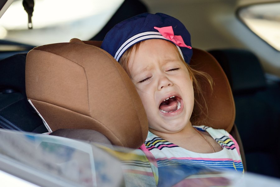 Niño llorando en asiento de automóvil