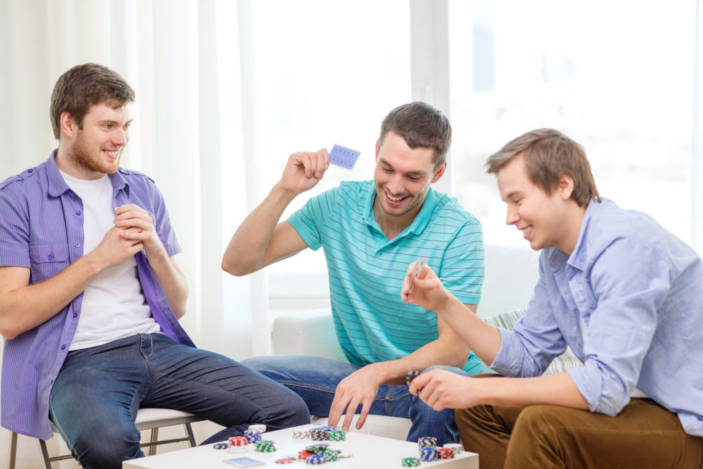 Juego de póker entre tres amigos varones
