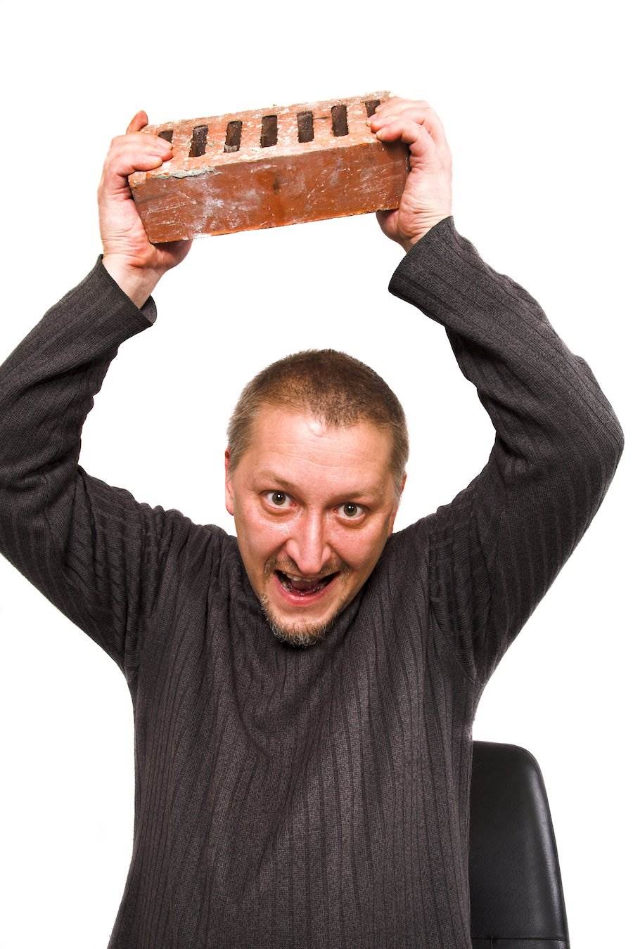 Man holding up brick about to strike