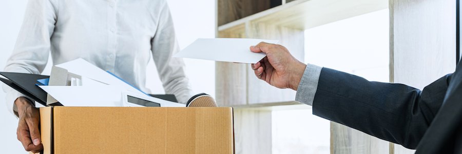 Jefe entregando el último cheque a un empleado despedido que lleva una caja