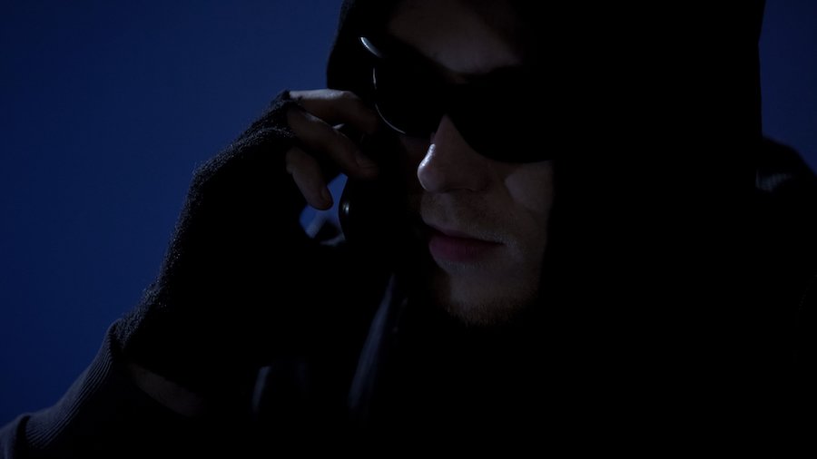 Hombre con capucha haciendo una llamada amenazante en violación de NRS 201.255