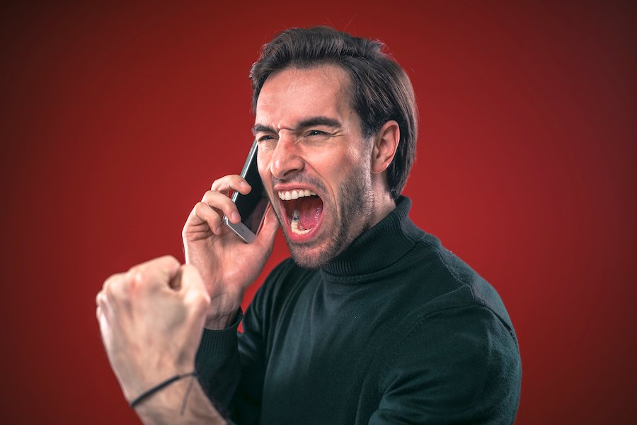 Hombre gritando en un teléfono celular