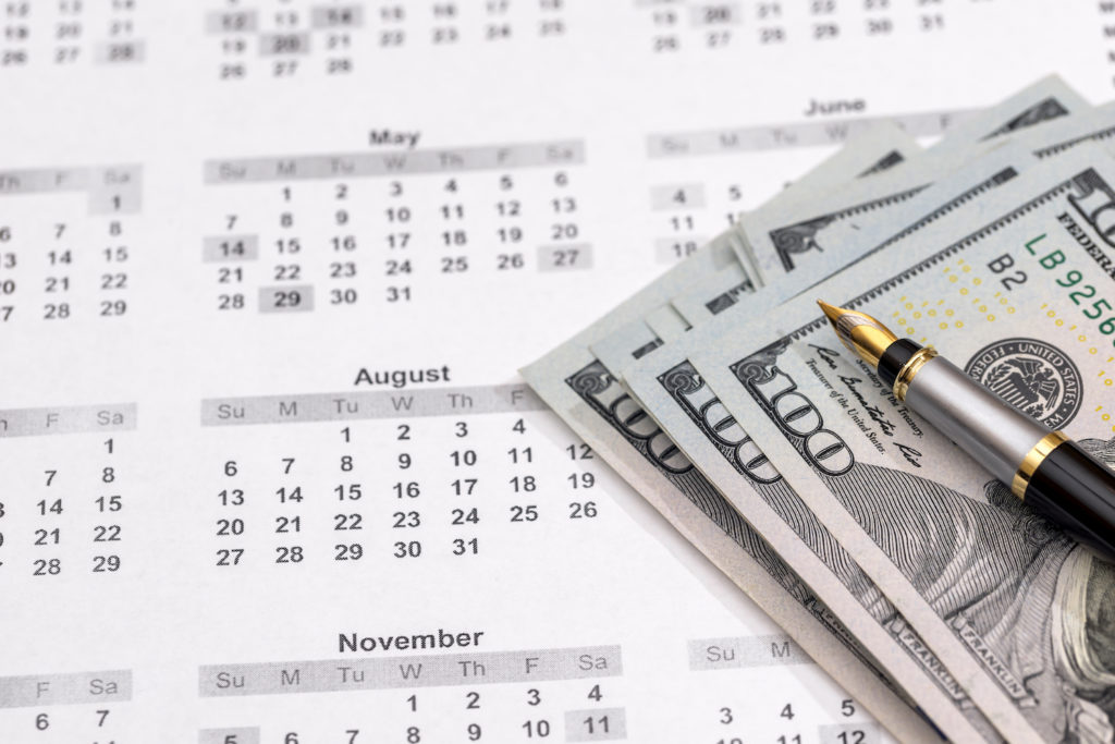 Calendar with cash and a pen