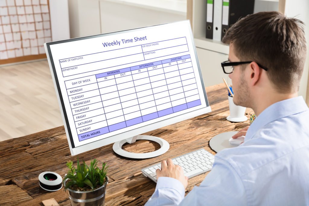 Worker filling out timesheet on computer