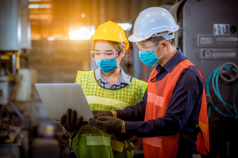 Two warehouse workers looking at clipboard