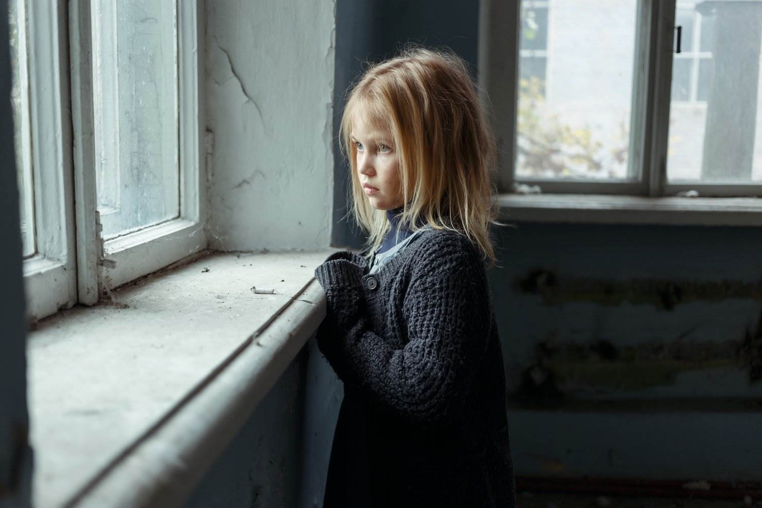 Child looking forlorn out of window