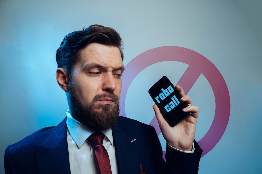 Hombre sosteniendo teléfono celular que dice llamada robótica