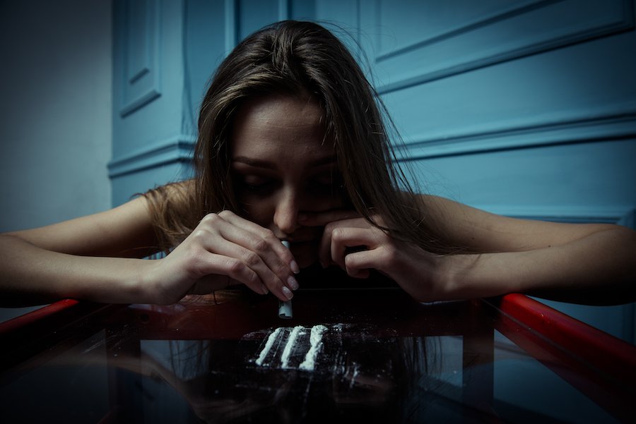 Girl snorting cocaine on table