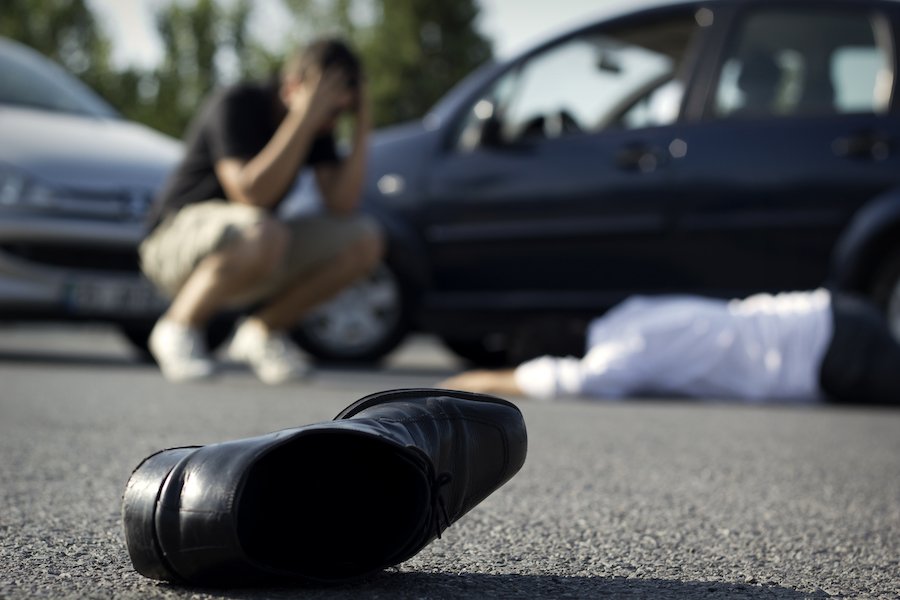 Driver holding his head in hands by victim after committing gross vehicular manslaughter while intoxicated