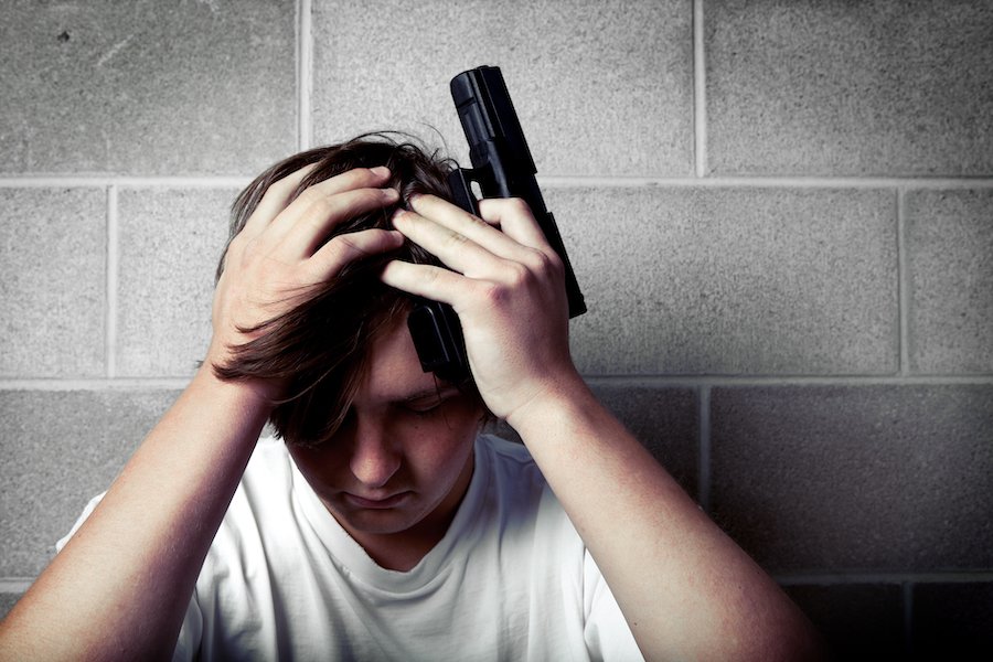 Teeenager against wall illegally possessing a handgun