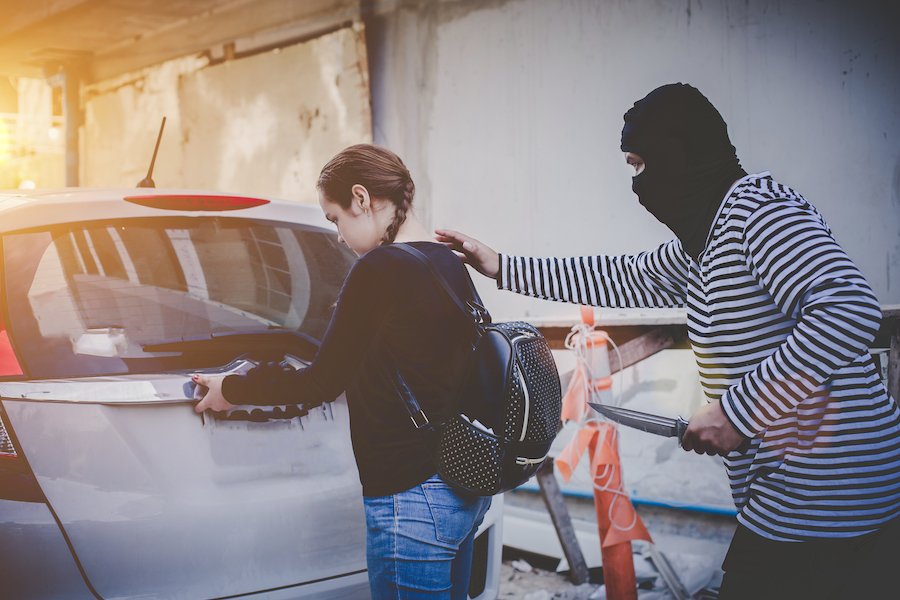 Chica siendo robada por hombre con máscara y cuchillo