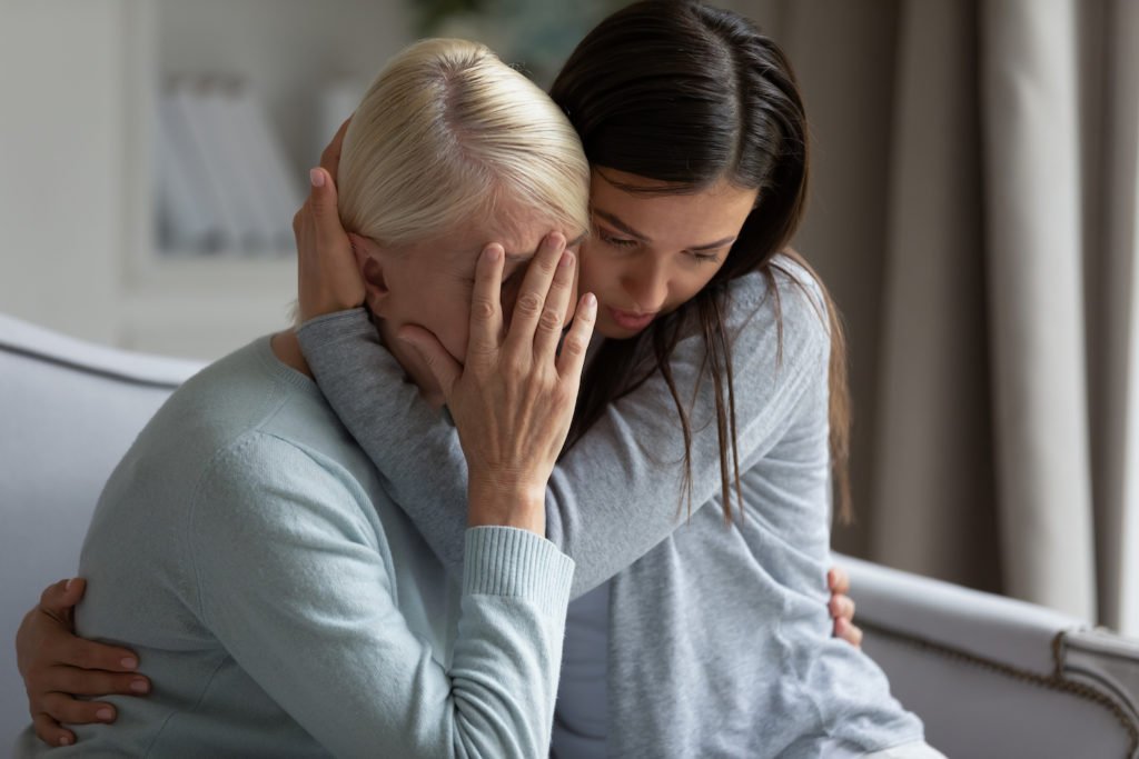 Young woman consoling older woman in mourning