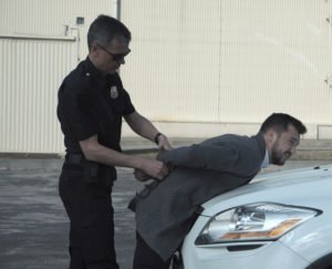 Police officer arresting person for violating restraining order