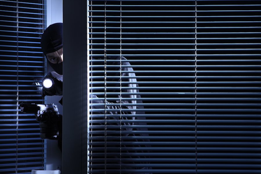 Hombre enmascarado con arma y linterna ingresando a una oficina en violación del NRS 205.060.