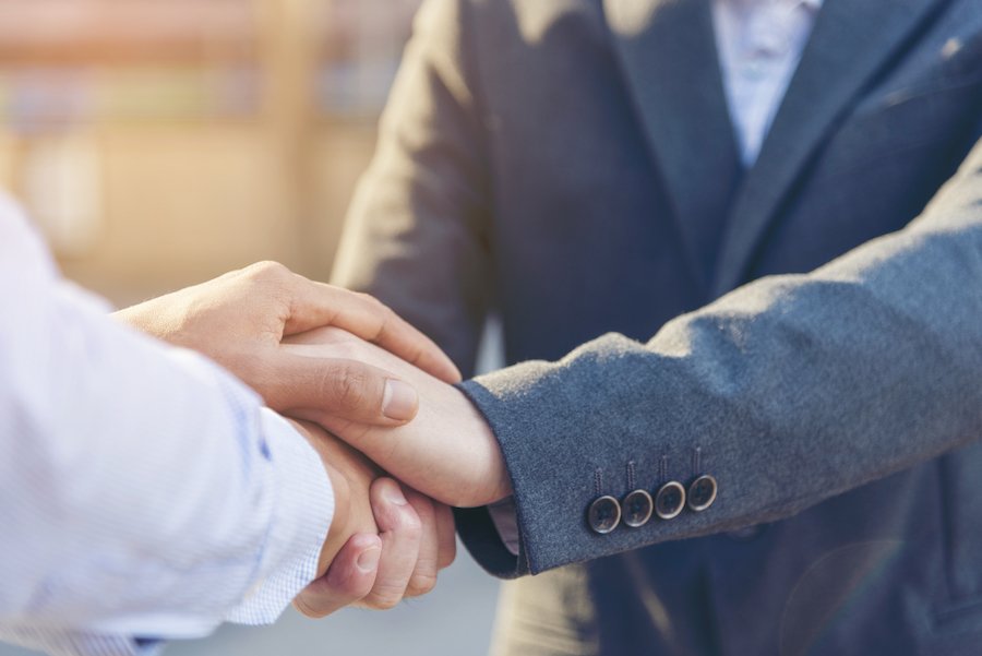 An attorney shaking hands with and comforting his client