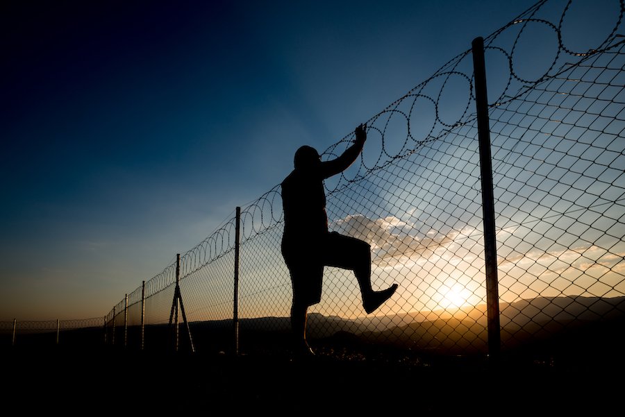 Jail inmate scaling fence in attempt to break out.
