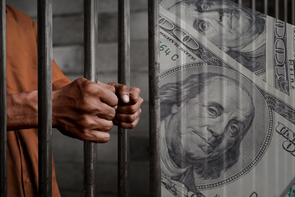 Man in jail cell and a 100 dollar bill - obtaining money by gambling fraud is a crime under Penal Code 332 PC