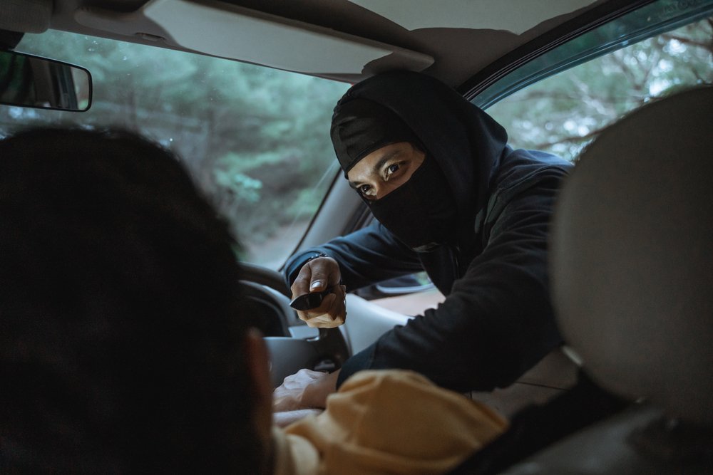 masked man pointing knife at driver