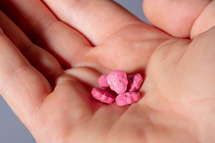 Palm holding five X tablets.