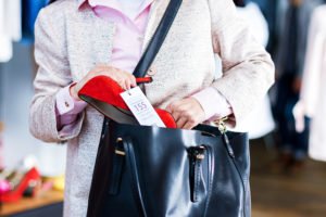 Woman shoplifting a shoe into her purse