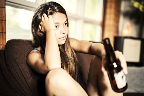 teen drinking a beer at home